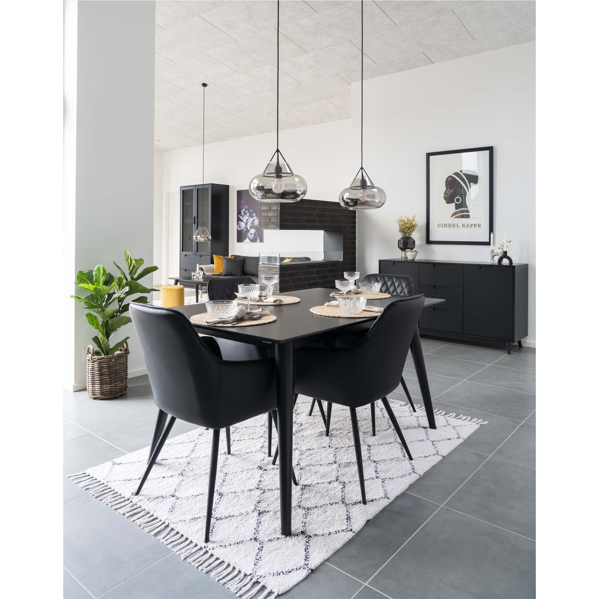 Fauteuils Harbo noirs autour table noire dressée salle à manger design suspensions verre