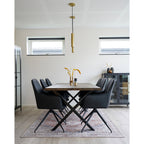 Fauteuils Harbo pivotants simili cuir noir autour table bois massif avec décoration florale et suspensions dorées