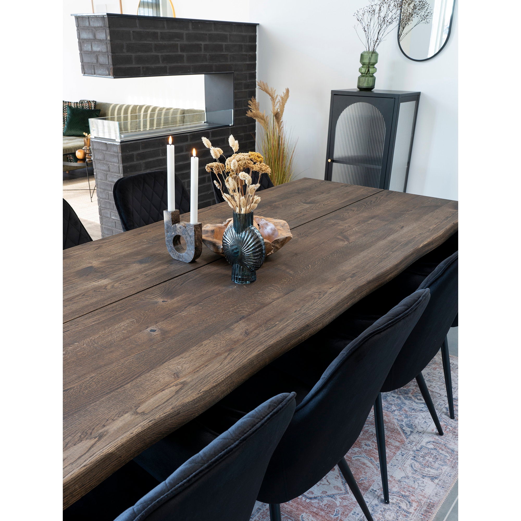 Fauteuils Harbo velours noir autour grande table bois salle à manger contemporaine cheminée et buffet cannelé