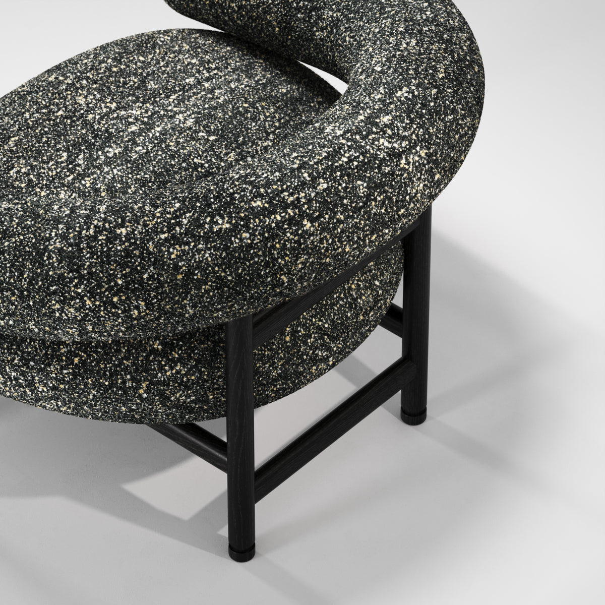 Piètement du fauteuil lounge Loop en chêne noir et tissu moucheté, vu de près
