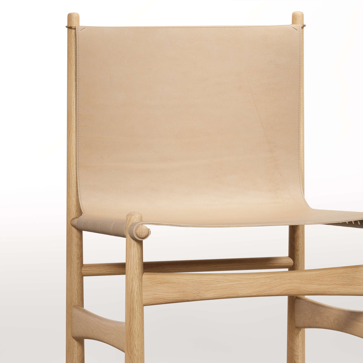 Dossier et assise du fauteuil lounge Nook en chêne et cuir naturel, vus de face, de près