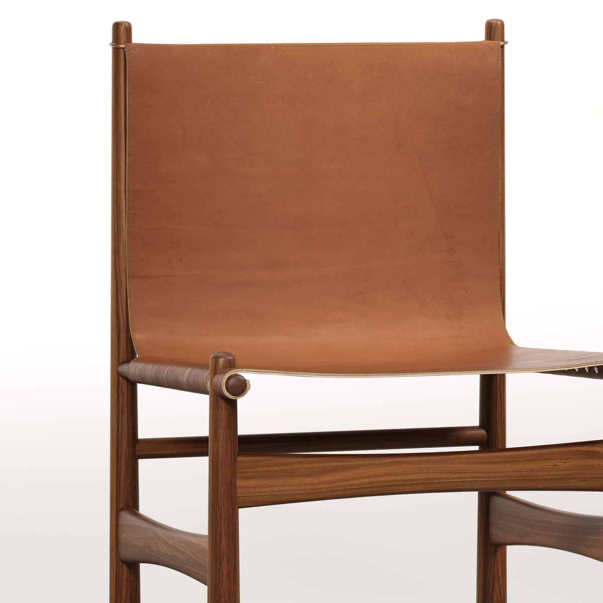 Dossier et assise du fauteuil lounge Nook en noyer et cuir noisette, vus de face, de près