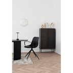 Fauteuil Monaco total look noir avec accoudoirs devant une table ronde noire dans intérieur minimaliste