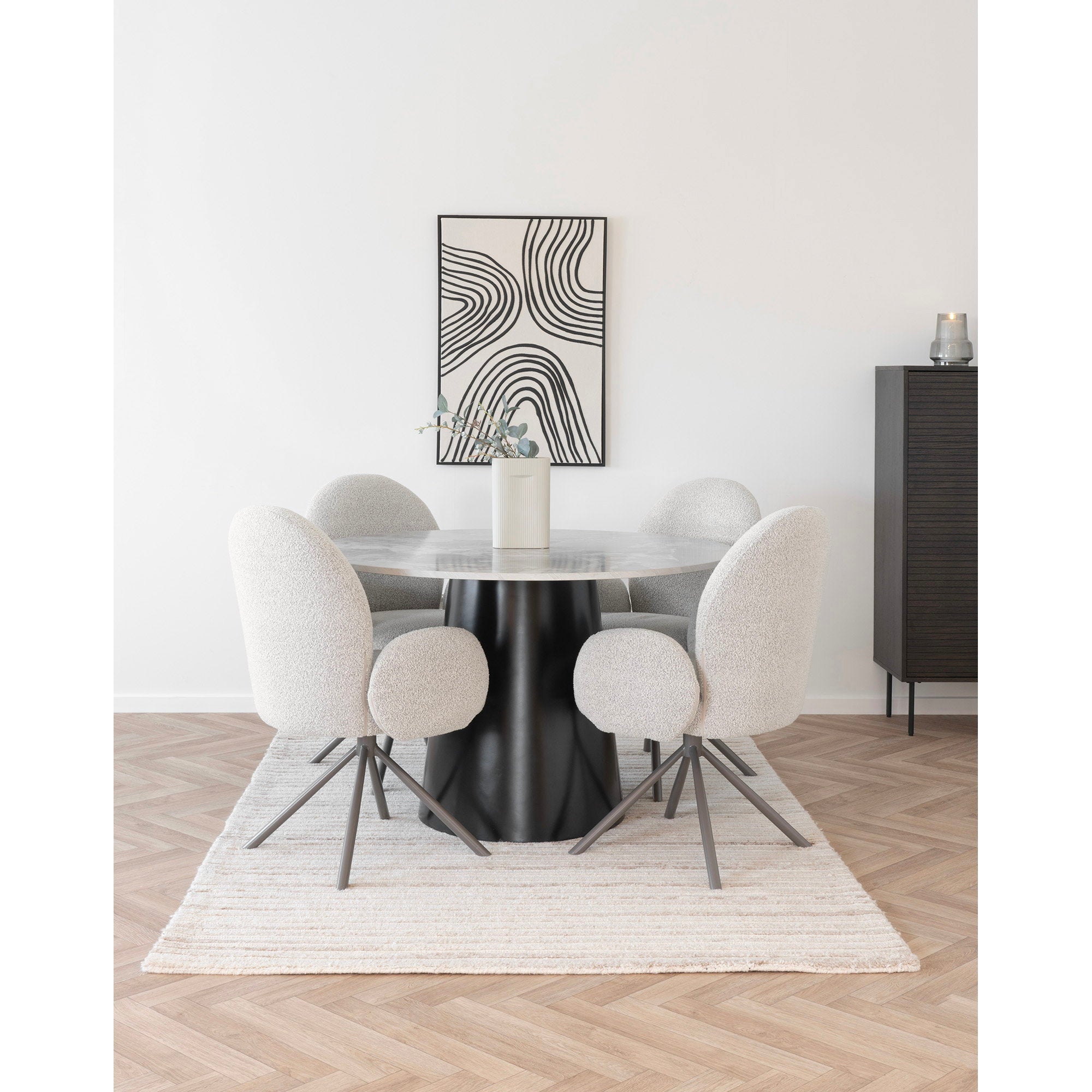 Fauteuils Lana bouclé sable accoudoirs intégrés autour d'une table ronde noire buffet noir