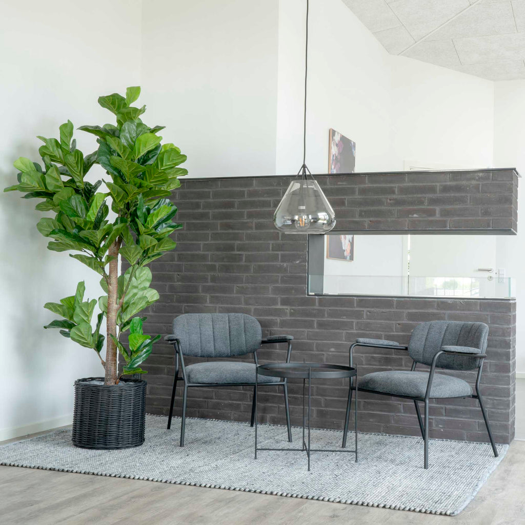 Ficus lyrata artificiel vert dans panier rotin noir espace industriel brique avec fauteuils gris