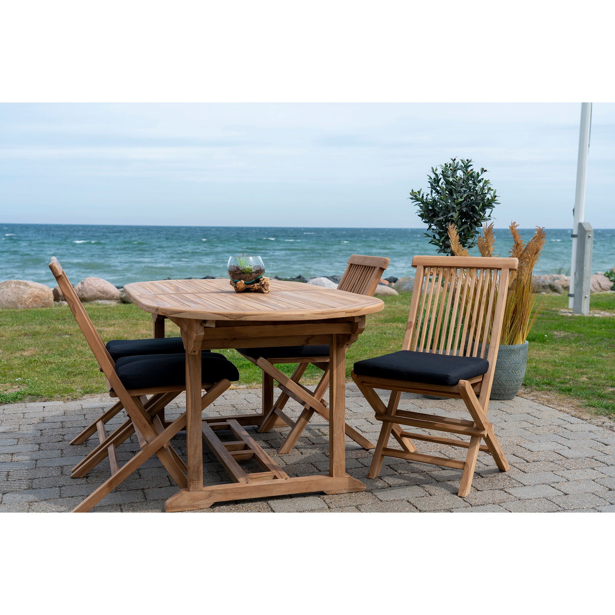 Galettes Alture noires sur chaises teck pliantes autour table ovale bord de mer