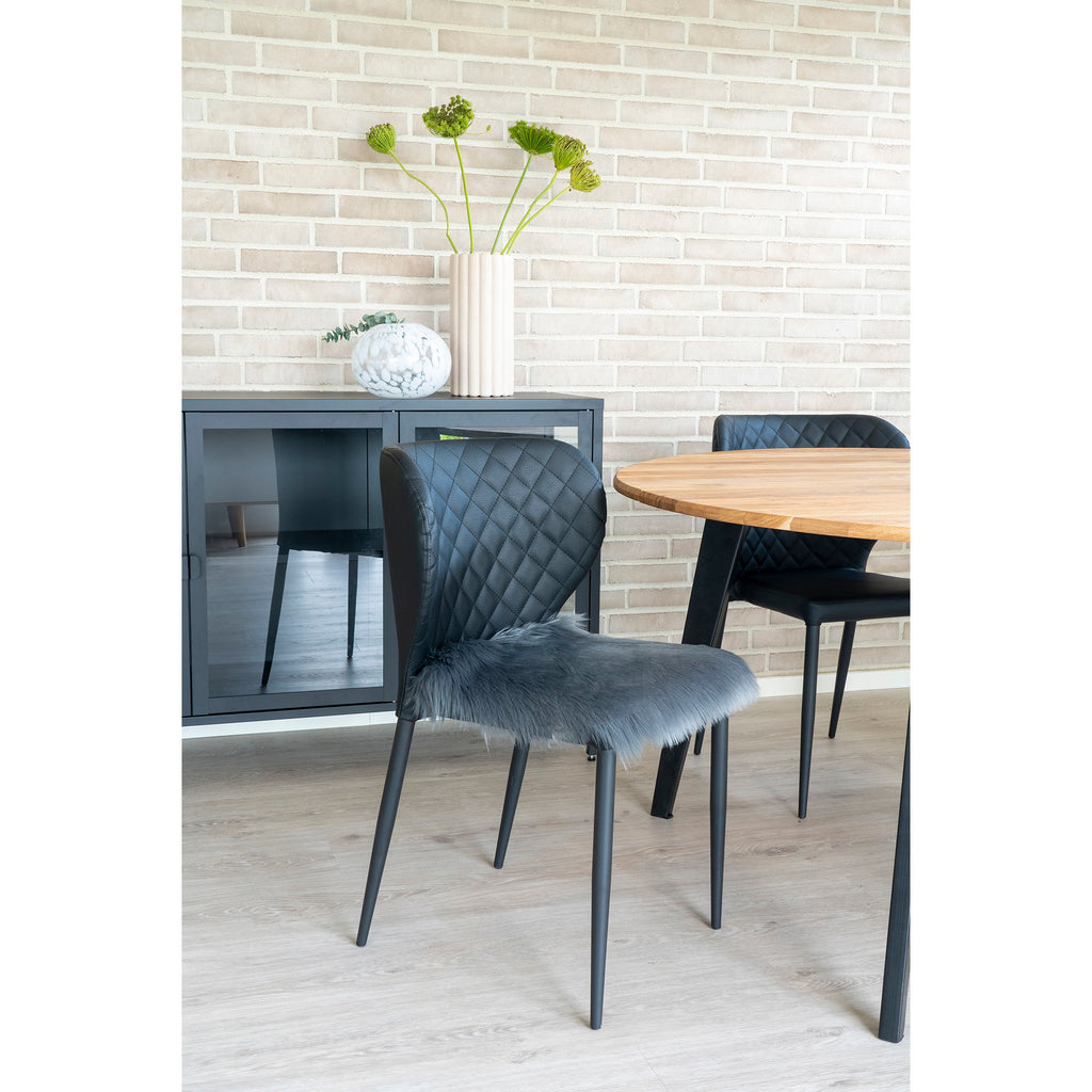 Galette chaise fausse fourrure gris anthracite posée chaise cuir noir table ronde bois
