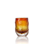 Gobelet en verre ambré dégradé vu de face avec sa paroi froissée et sa semelle incolore