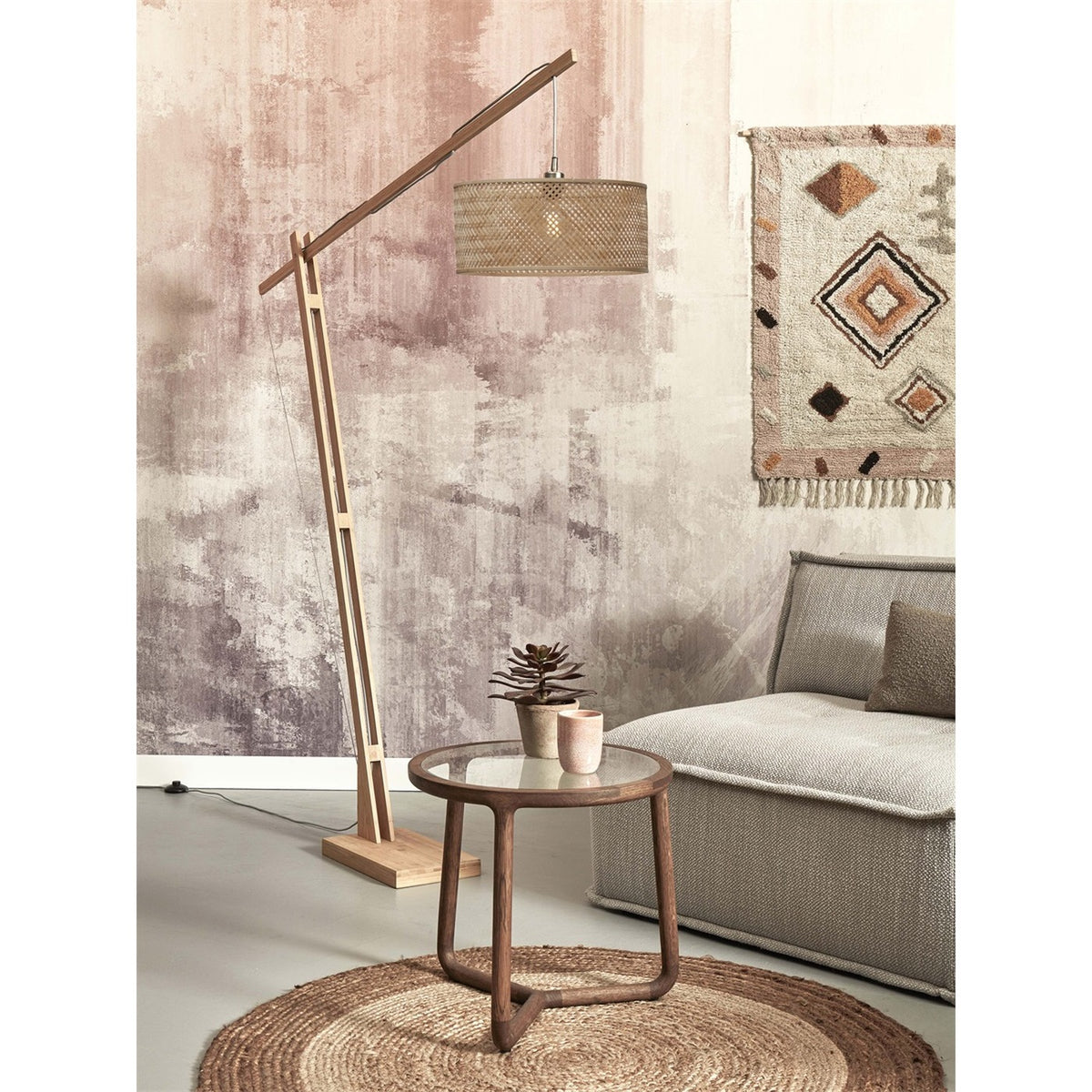 Lampadaire déporté Java bambou naturel abat-jour uni allumé près d'une chauffeuse grise et d'un tapis rond en jute