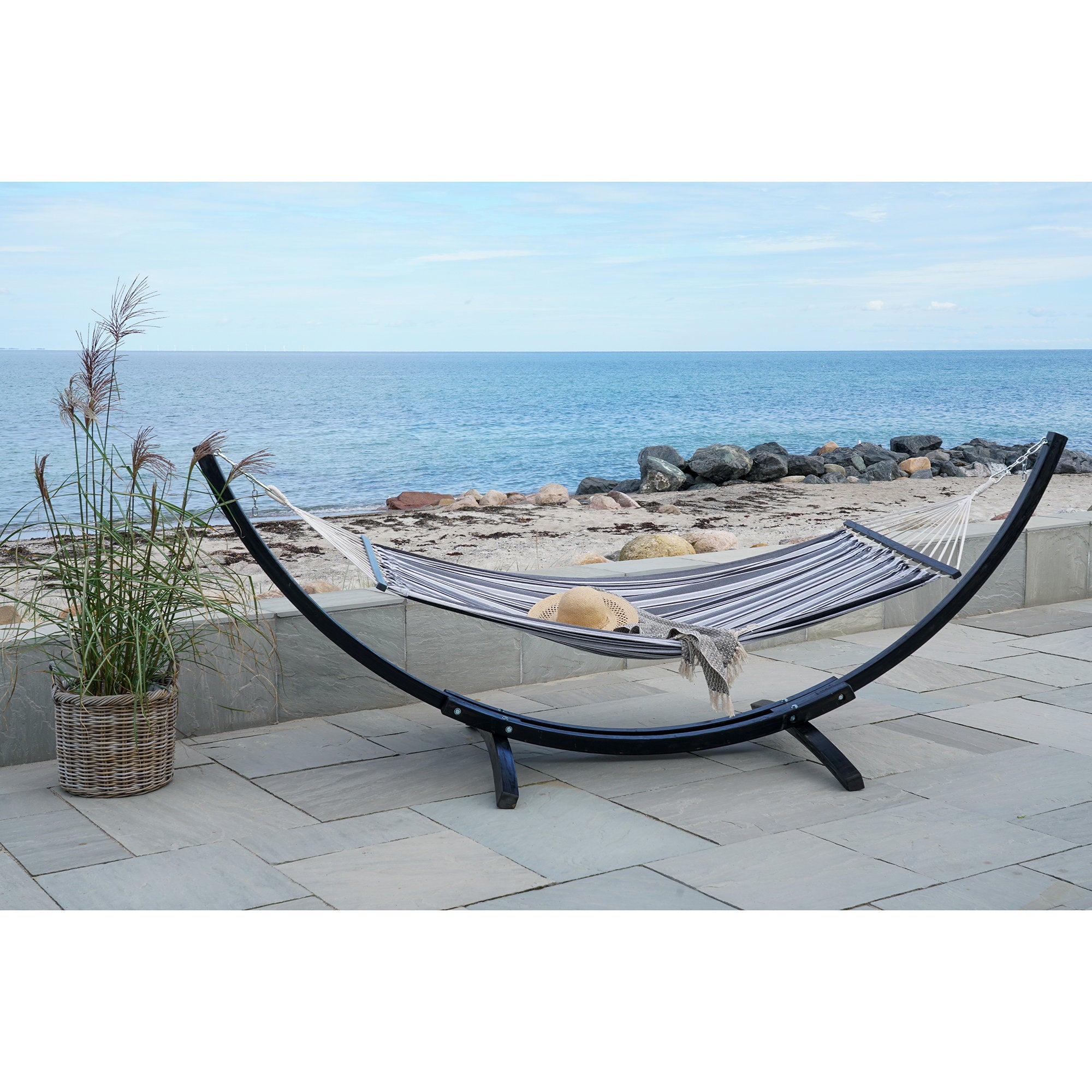 Hamac Tripoli rayé noir gris sur support bois terrasse bord de mer chapeau paille
