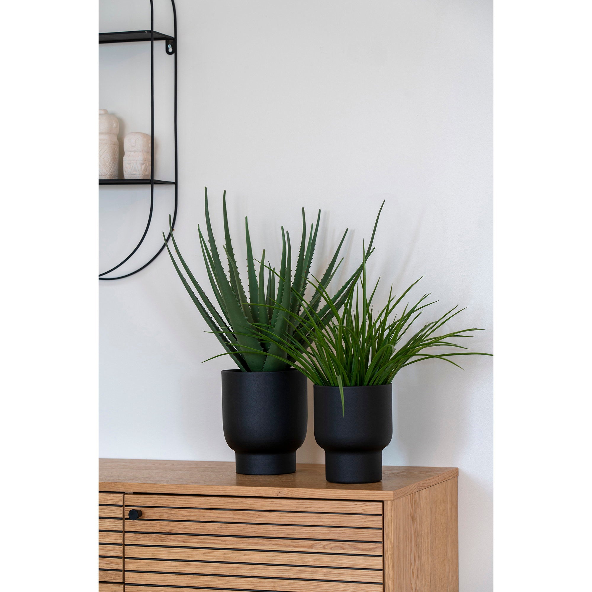 Plante artificielle herbe ornementale dans cache-pot noir sur buffet bois décoration salon