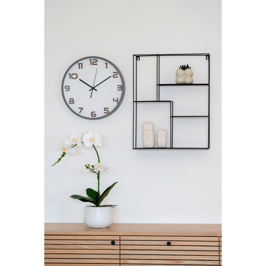 Horloge Greenwich gris et bois en ambiance salon scandinave au-dessus d'un meuble TV chêne