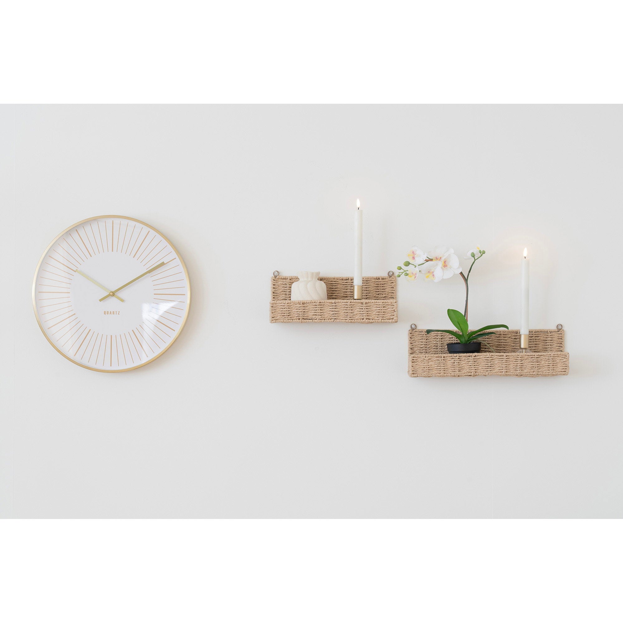 Horloge Takamaka dorée en ambiance salon mur blanc avec paniers muraux et bougies