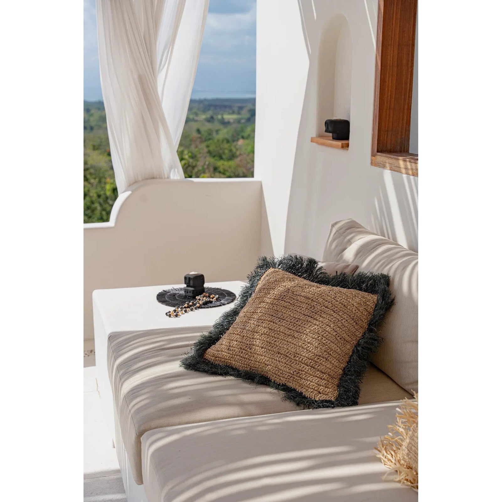 Housse de coussin en raphia naturel à frange noire 60x60 cm en situation