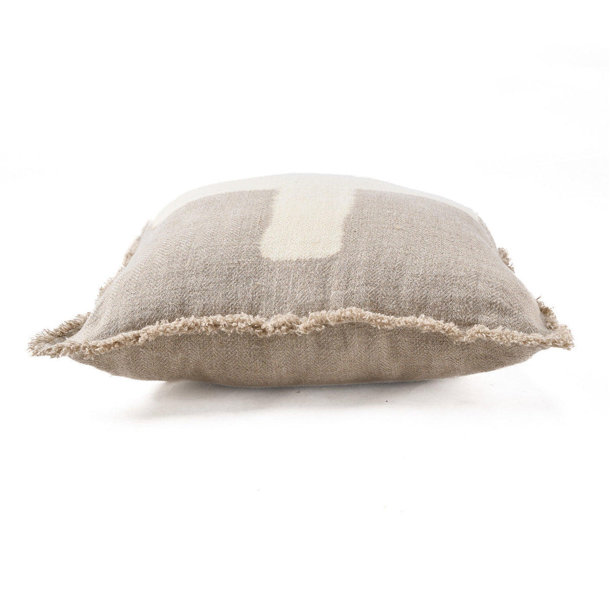 Housse de coussin Ivory Cross vue de profil qui montre son épaisseur et sa frange