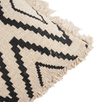 Gros plan sur un angle de la housse de coussin Sahara Diamond et sur sa frange en coton écru