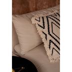 Détail de la frange écrue de la housse de coussin Sahara Diamond posée contre un coussin uni