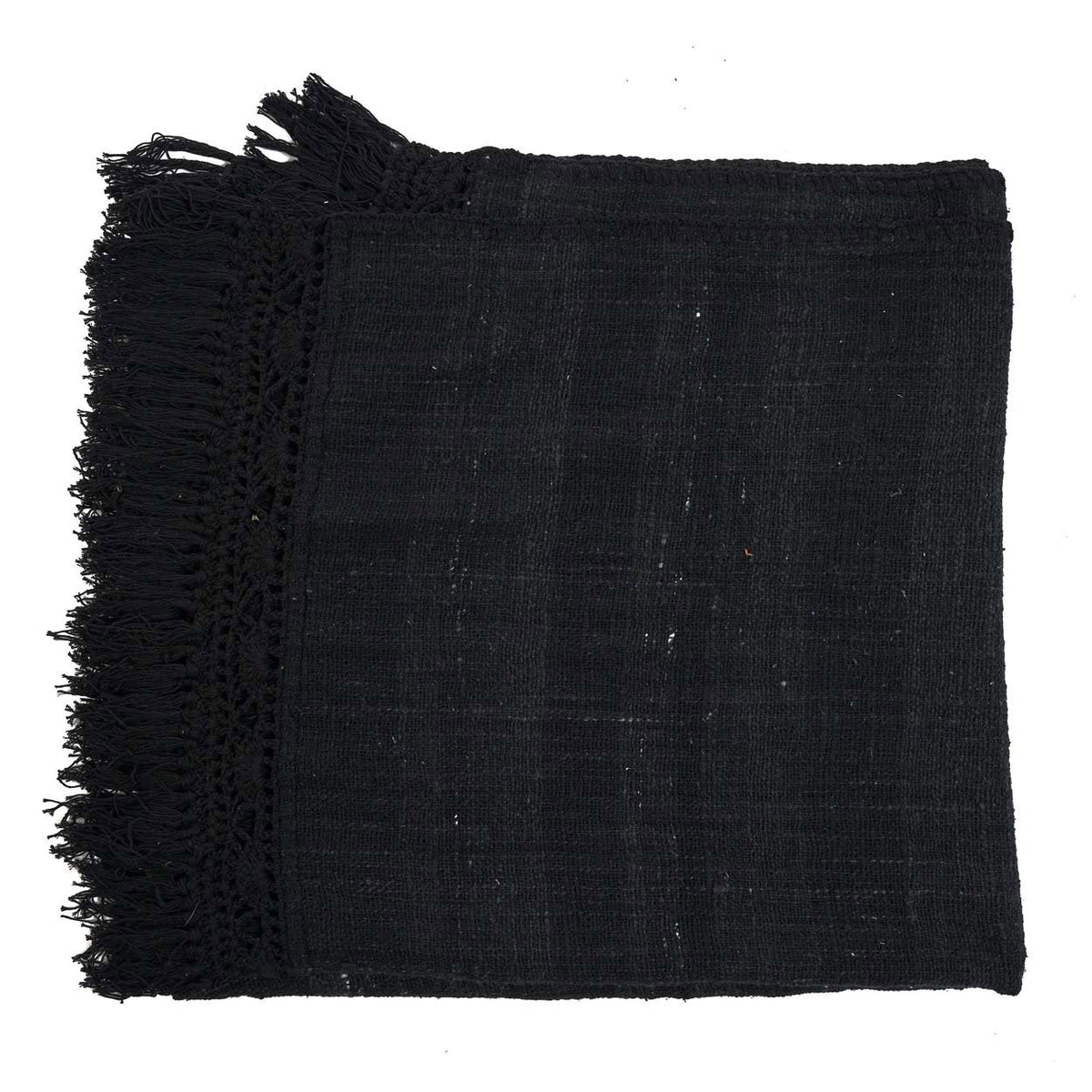 Jeté de lit Gypsy en coton noir plié à plat montrant le grain irrégulier de la toile et la frange