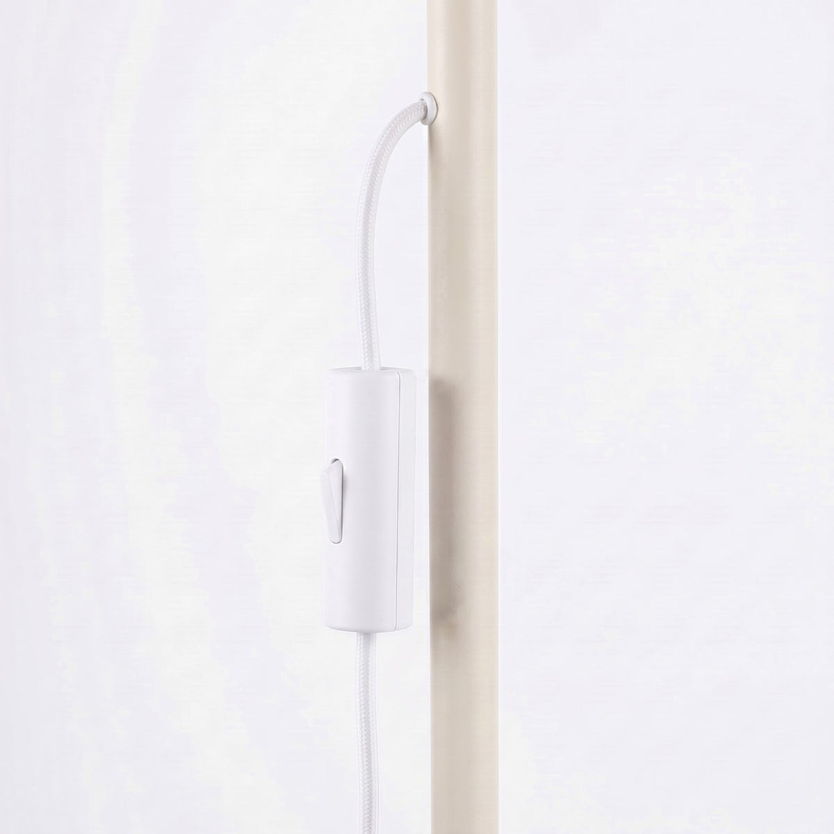 Interrupteur sur le câble blanc du lampadaire Karbon laque beige le long du pied
