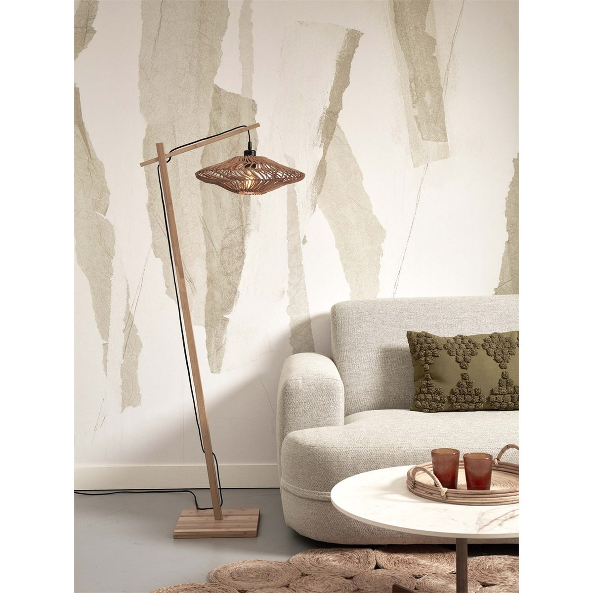 Lampadaire liseuse Zanzibar rotin naturel 40 cm allumé à côté d'un canapé clair et d'une table basse ronde