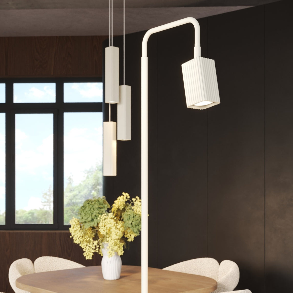 Tête allumée du lampadaire Rayo 1 laque beige devant une suspension Rayo trois spots
