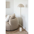 Lampadaire Sheffield dans un angle de salon à côté d'un canapé courbe en bouclette taupe