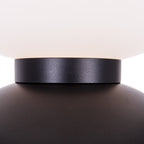 Détail de la bague noire entre un globe de verre dépoli blanc et une boule de métal noir du lampadaire Tama