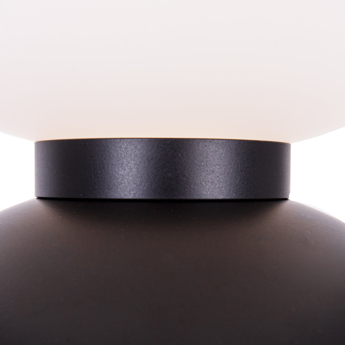 Détail de la bague noire entre un globe de verre dépoli blanc et une boule de métal noir du lampadaire Tama