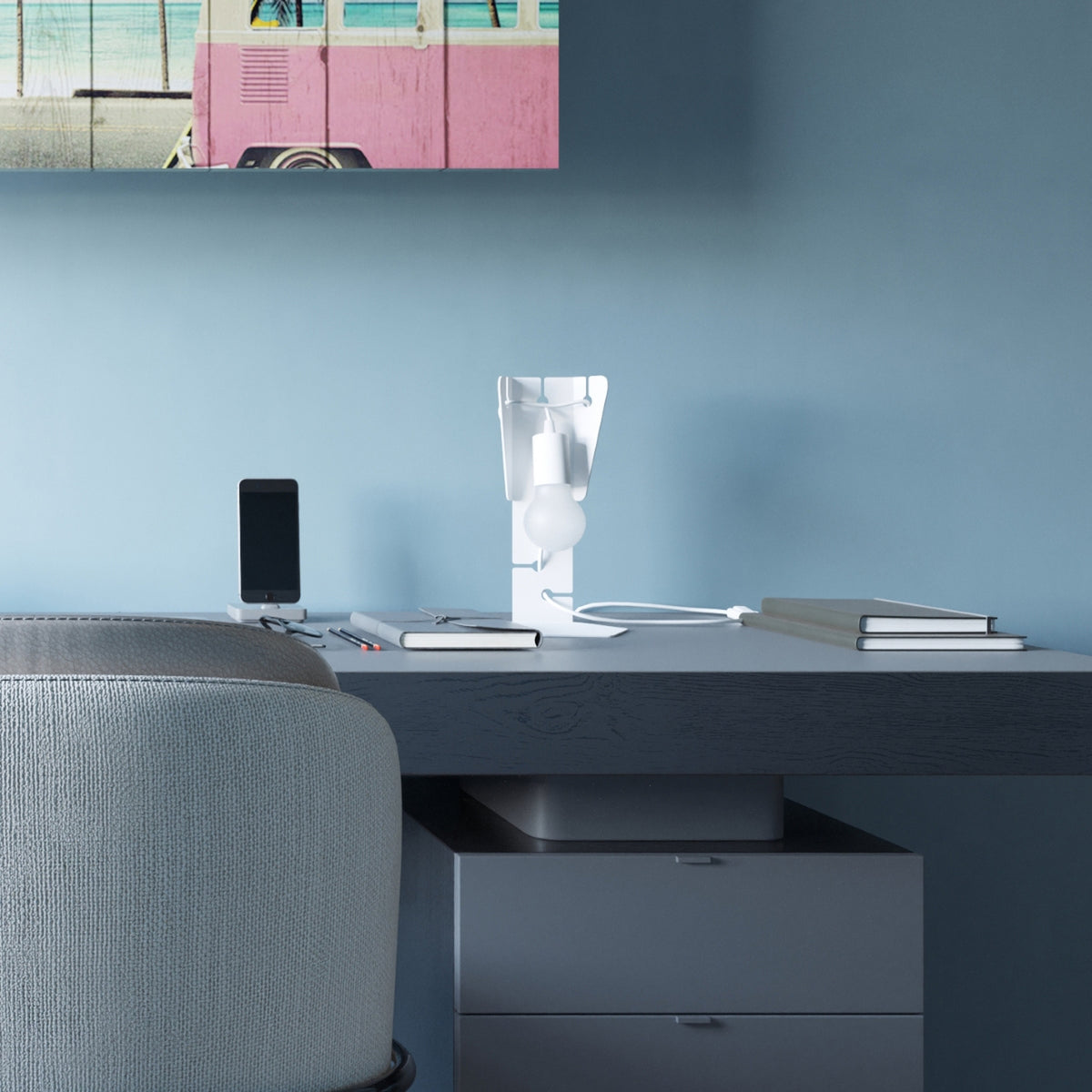 Lampe Arby métal blanc avec ampoule globe sur un bureau près d'un fauteuil en tissu