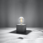 Lampe à poser Ariz en béton brut, cube à ampoule apparente, ampoule allumée