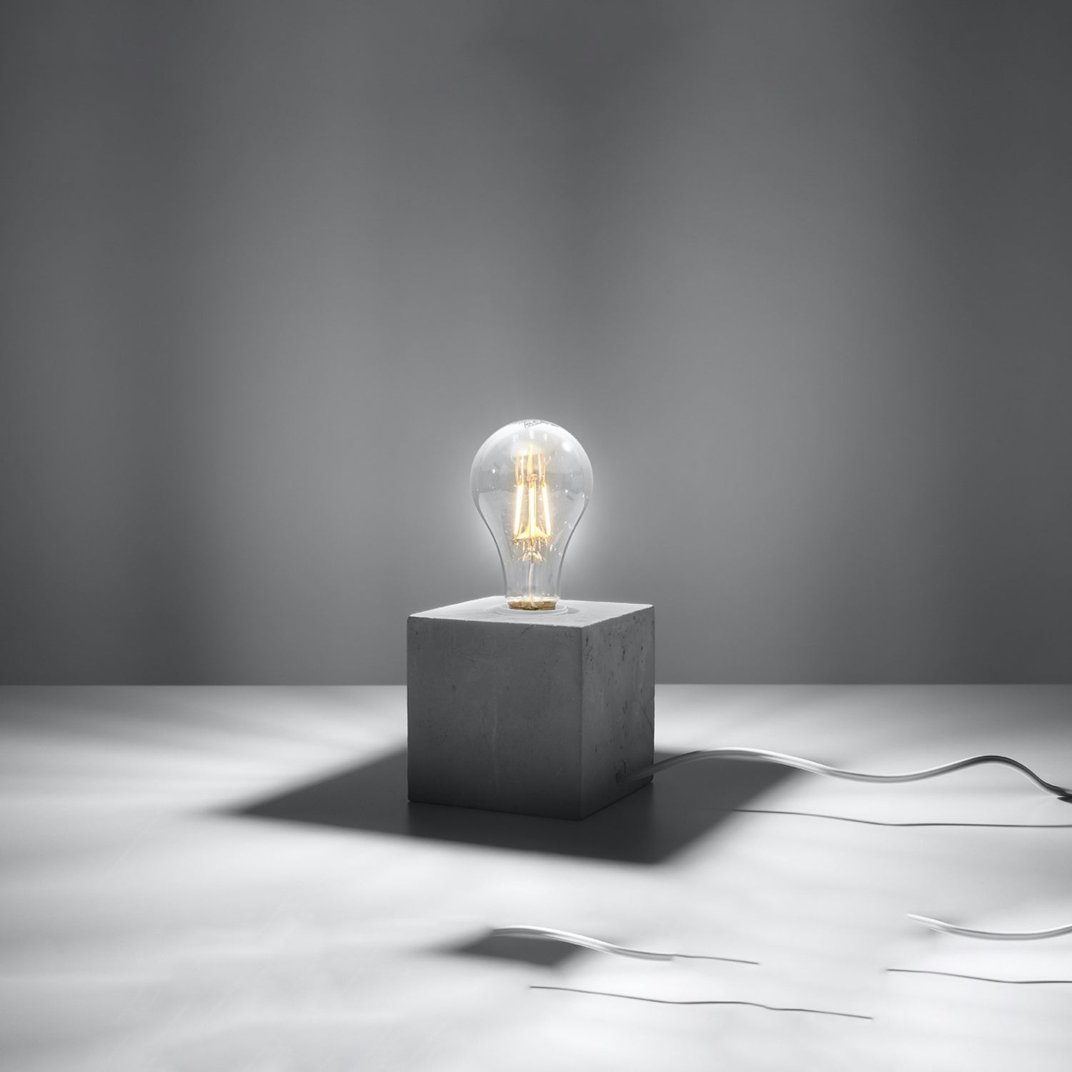 Lampe à poser Ariz en béton brut, cube à ampoule apparente, ampoule allumée