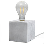 Lampe à poser Ariz en béton brut, cube à ampoule apparente, vue de face