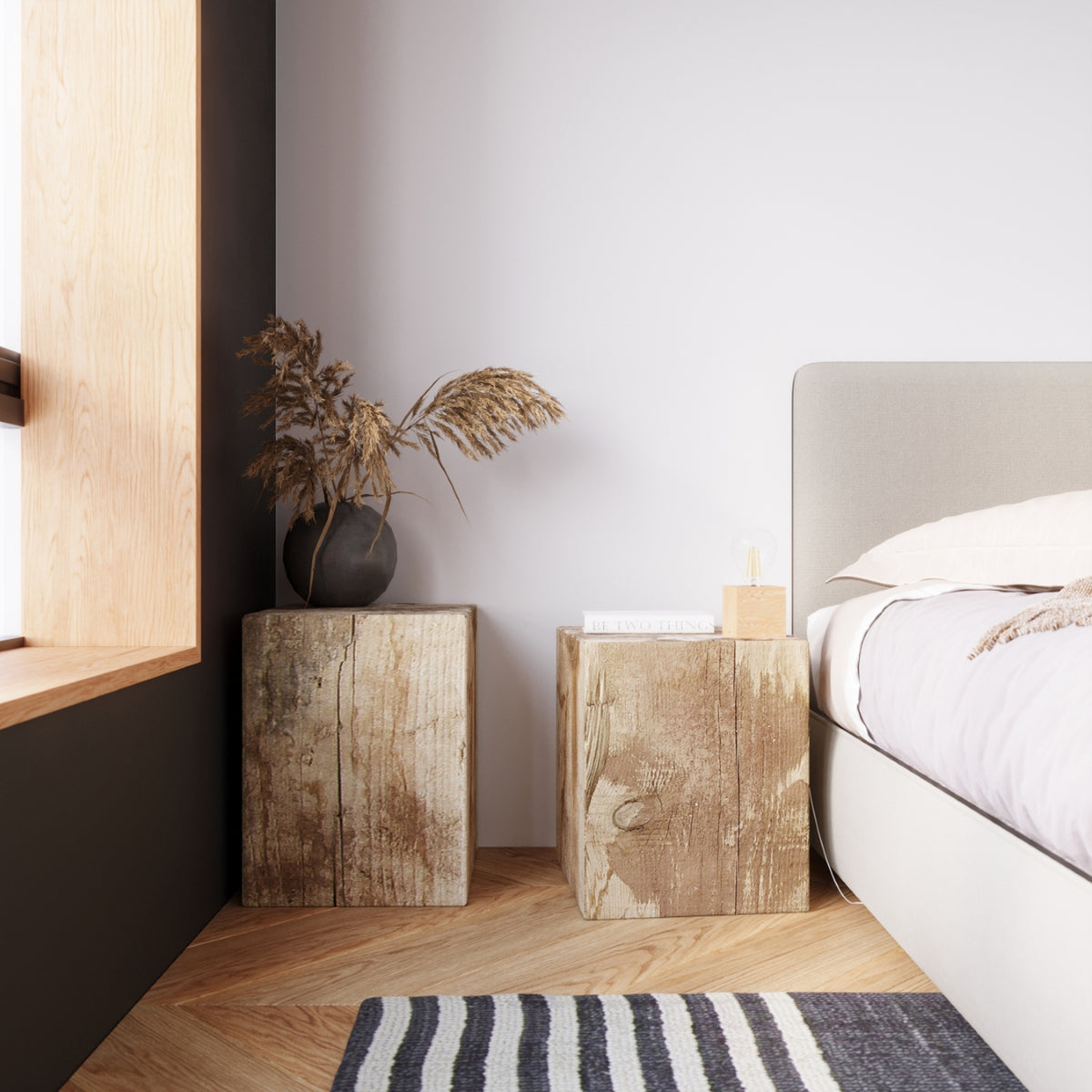 Lampe à poser Ariz bois clair sur une table de chevet en bois brut près d'un lit