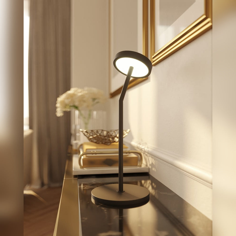 Lampe à poser Ibiza allumée sur une console de marbre sombre sous un miroir doré