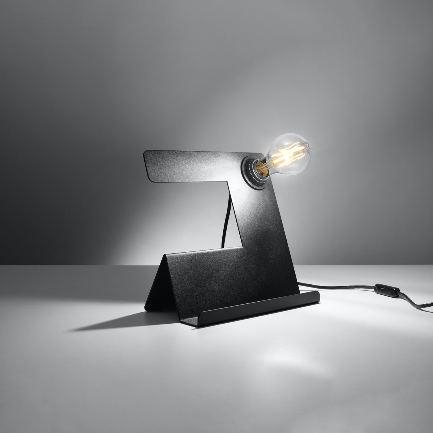 Lampe à poser Incline en acier noir, tôle pliée et ampoule apparente, ampoule allumée