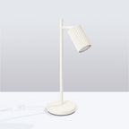 Lampe à poser Karbon spot cannelé beige posée sur un bureau