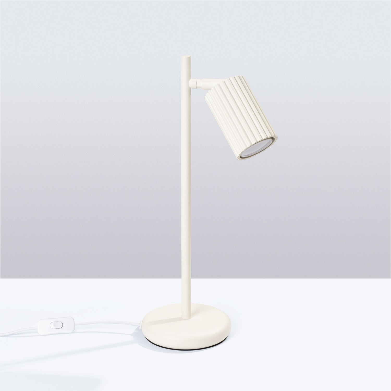 Lampe à poser Karbon spot cannelé beige posée sur un bureau