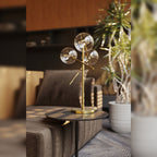 Lampe à poser Lollipop métal couleur laiton sur une table d'appoint ronde à côté d'un canapé en tissu