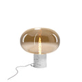 Lampe à poser Moonstone verre ambré et marbre blanc détourée allumée globe ovale sur socle cylindrique