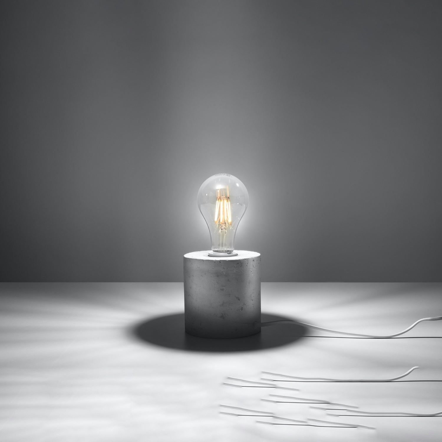 Lampe à poser Salgado en béton brut, cylindre à ampoule apparente, ampoule allumée