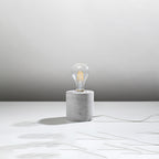 Lampe à poser Salgado en béton brut, cylindre à ampoule apparente, vue de profil
