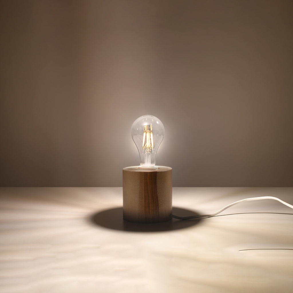 Lampe à poser Salgado en bois naturel, cylindre massif à ampoule apparente, ampoule allumée