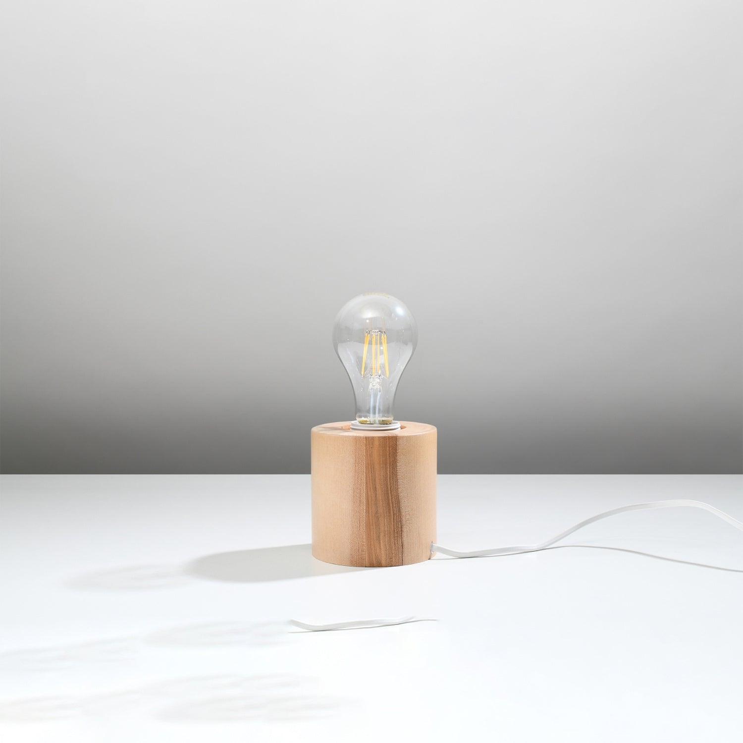 Lampe à poser Salgado en bois naturel, cylindre massif à ampoule apparente, vue de profil
