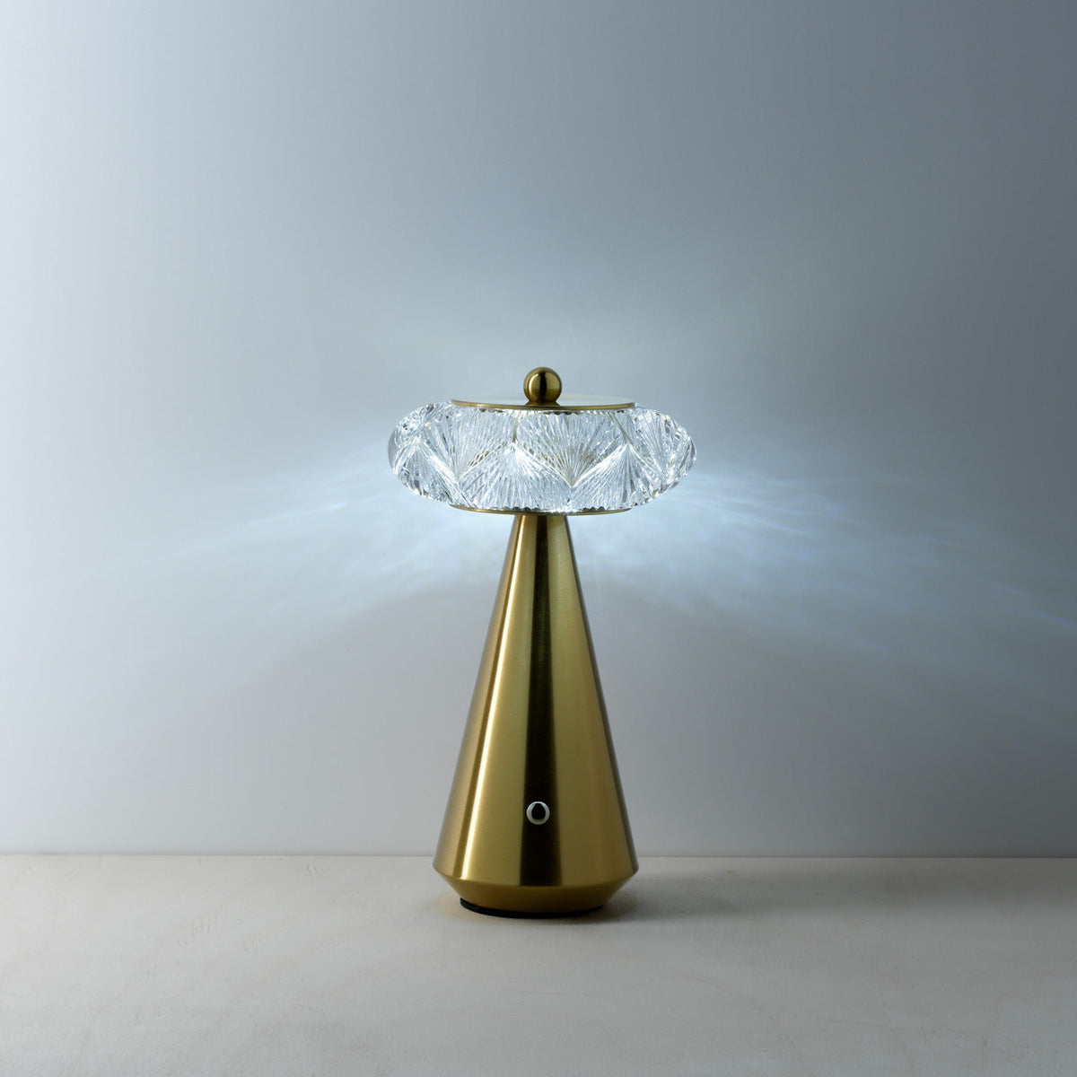 Lampe Diamond Diva allumée en lumière froide projetant des reflets bleutés sur le mur