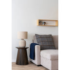 Lampe Bilby céramique marbrée sur une table d'appoint en bois foncé dans un salon