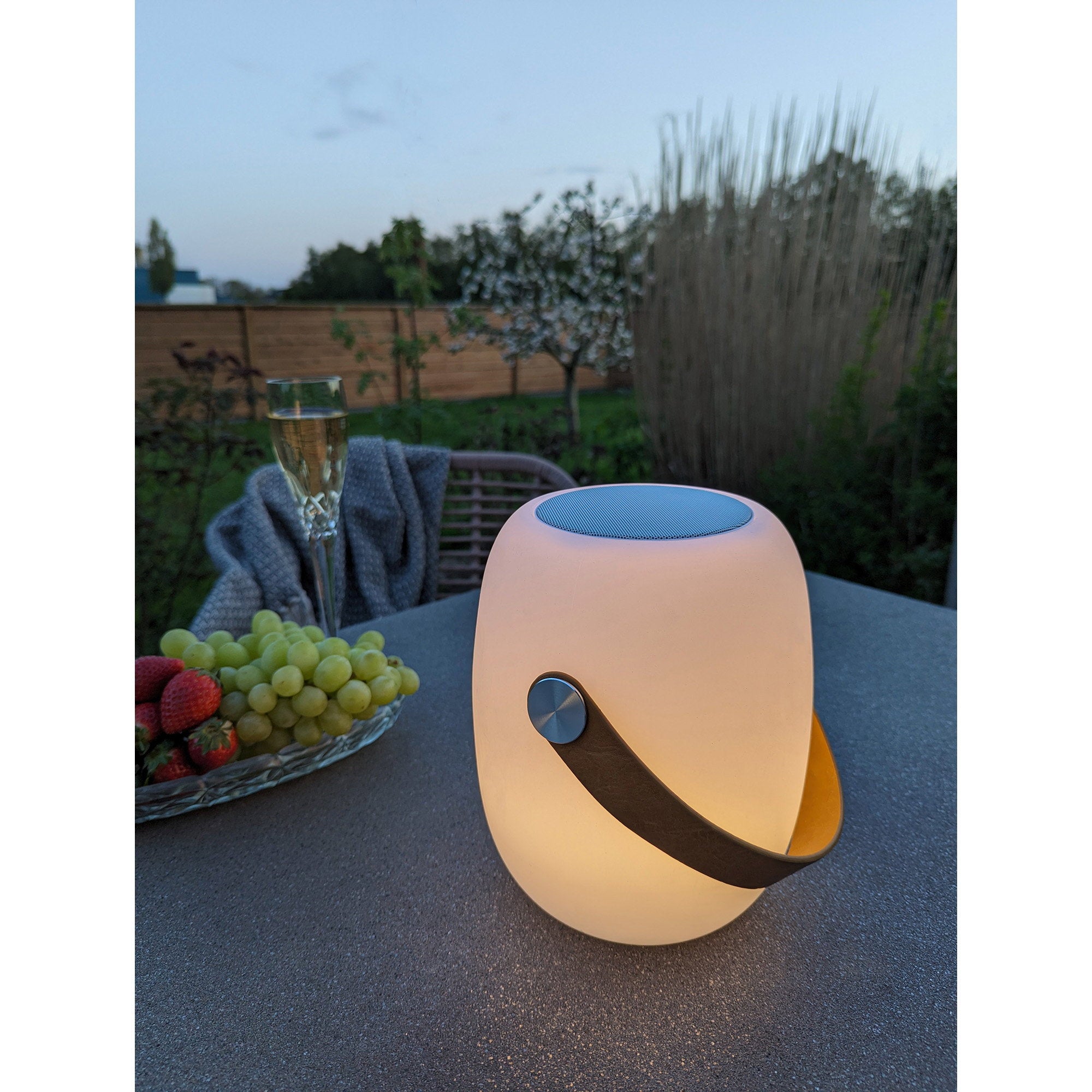 Lampe Cardiff allumée lumière chaude table terrasse nuit ambiance soirée champagne jardin