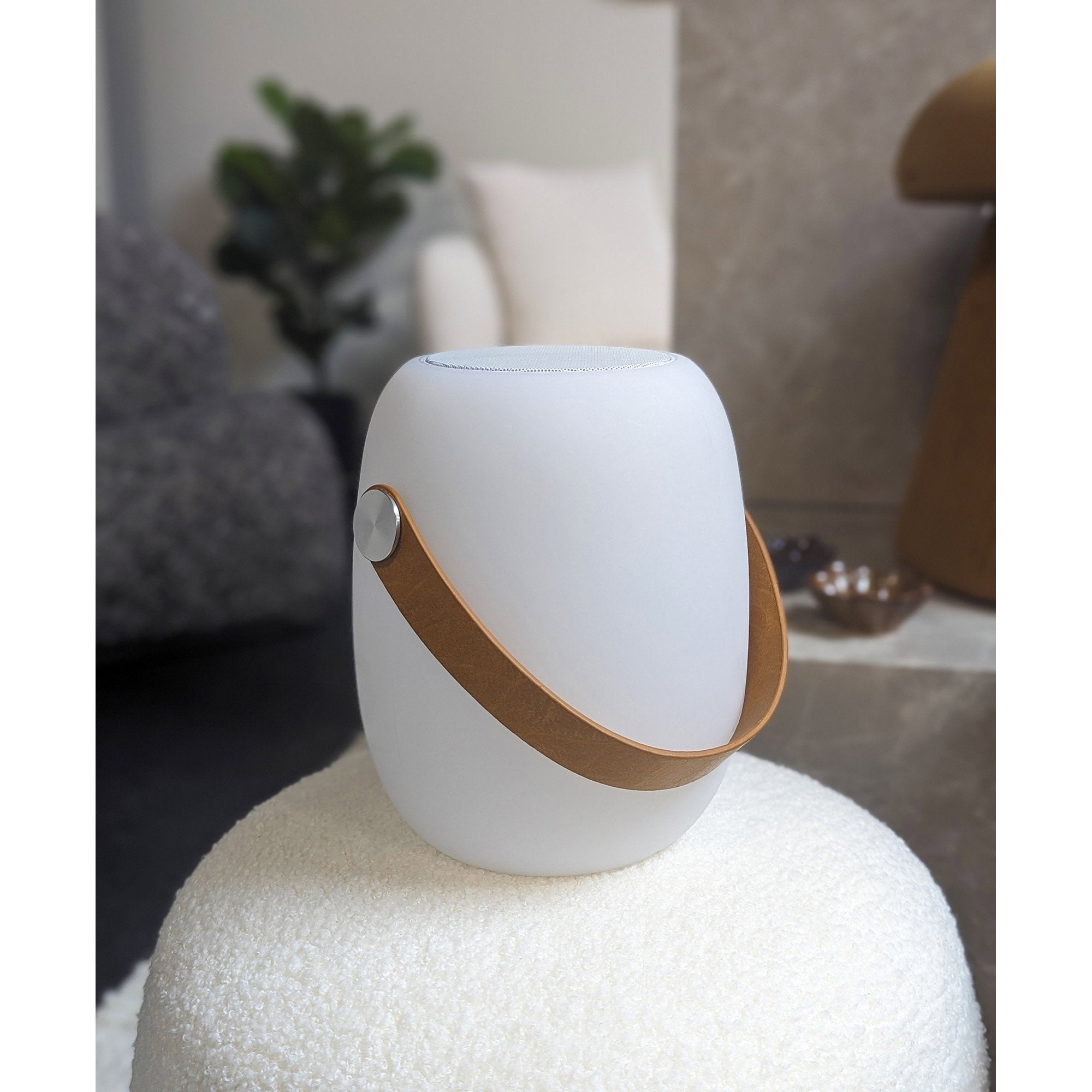 Lampe LED Cardiff blanche enceinte Bluetooth posée sur pouf bouclette ambiance cosy salon