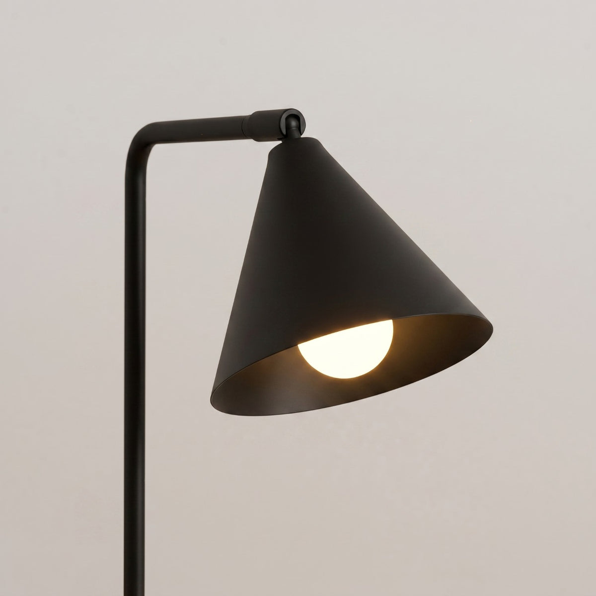 Gros plan sur le cône de la lampe Nox laque noire éclairé par une ampoule