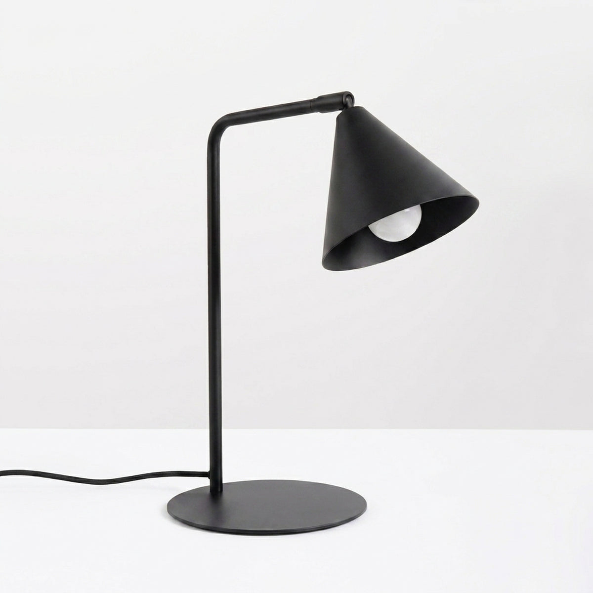 Lampe de bureau Nox laque noire posée sur fond clair ampoule éteinte