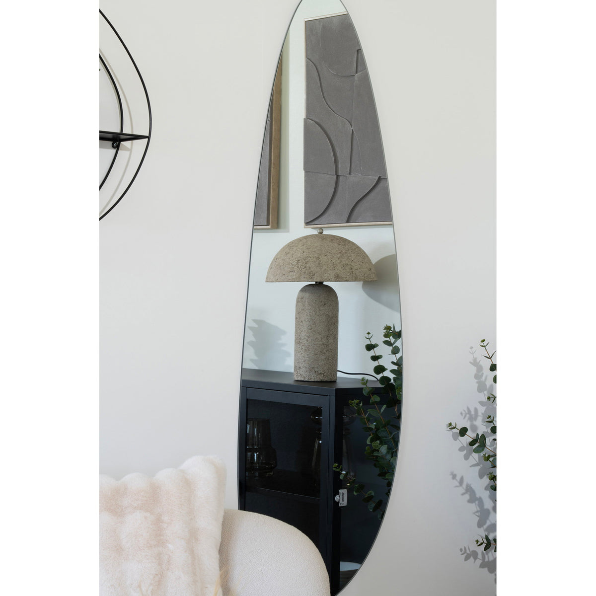 Lampe Astley pierre grise sur un buffet noir reflétée dans un grand miroir organique